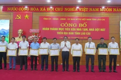 The collectives with oustanding achievements in the substandard housing eradication programme are granted certificates of merit by the Lao Cai provincial People's Committee at the ceremony on June 19. (Photo: VNA)