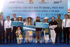 The organising committee presents flowers and gifts to lucky passengers boarding the Osaka – Da Nang flight at the welcome ceremony. (Photo: VNA) 