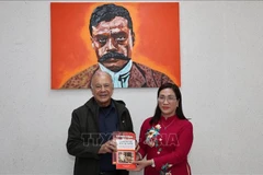 Alberto Anaya Gutiérrez, General Secretary of the Labour Party (PT) of Mexico, presents Dinh Thi Mai, Deputy Head of the Party Central Committee’s Commission for Information, Education and Mass Mobilisation, with Spanish-language publications on Vietnam printed and distributed by the PT in Latin America. (Photo: VNA) 