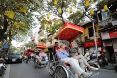 Foreign visitors explore Hanoi’s old quarters by cyclo, admiring the city’s timeless beauty. (Photo: VNA)
