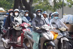 Motorbike riders in Huế City wear sun-protective gear as they travel along Trần Hưng Đạo Street amid the intense heatwave. (Photo: VNA) 