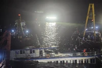At 2:00 a.m. on July 20, rescue teams begin pumping water out of the capsized tourist boat before towing it ashore. (Photo: VNA)