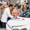 Indonesian President Joko Widodo signs on a VinFast car during the launch event of the Vietnamese automaker’s right-hand drive EVs in the market on February 15, 2024. (Photo: VNA)