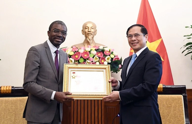 Deputy Prime Minister and Foreign Minister Bui Thanh Son awards Lazare Eloundou Assomo, Director of the UNESCO World Heritage Centre, the “For the Cause of Vietnam’s Diplomacy” insignia at their meeting on May 19. (Photo: Baochinhphu.vn)