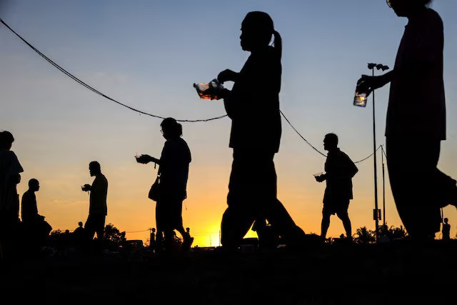 Displaced people walk after receiving food at a temporary shelter amid clashes between Thailand and Cambodia along a disputed border area, in Buriram province, Thailand, December 16, 2025. (Photo: Reuters)