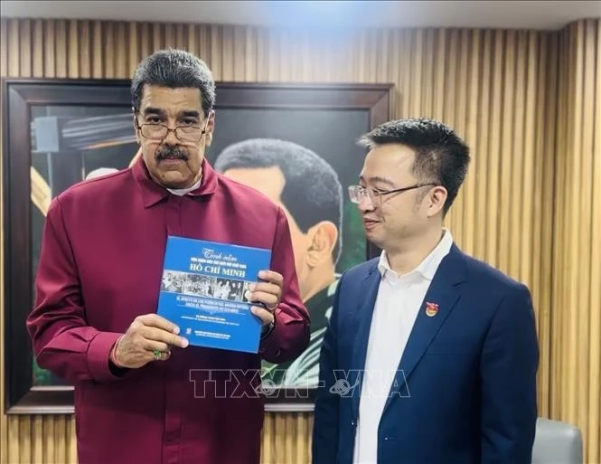 Venezuelan President Nicolas Maduro receives the Spanish edition of "The world's affection for President Ho Chi Minh" from Nguyen Tuong Lam, Secretary of the Ho Chi Minh Communist Youth Union Central Committee. (Photo: Vietnamese Embassy in Venezuela)
