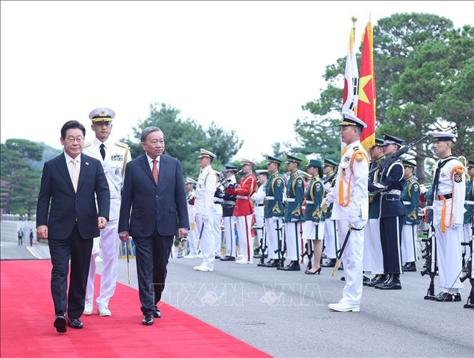Korean President Lee Jae Myung and Party General Secretary To Lam review the guard of honour at the welcome ceremony. (Photo: VNA)