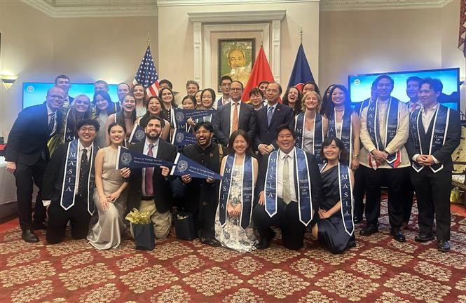 The Vietnamese Embassy's staff in the U.S. pose for a photo with Southeast Asian Studies Master’s Graduates. (Photo: VNA)