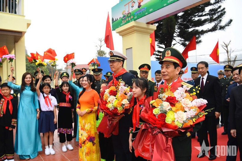 Students present flowers to the two defence ministers. (Photo: qdnd.vn)