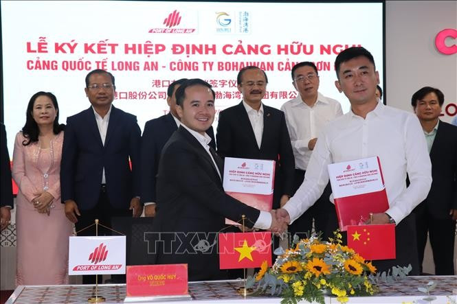 Chairman of the Board of Long An International Port, Vo Quoc Huy (left), signs a cooperation agreement with Chinese partner. (Photo: VNA)