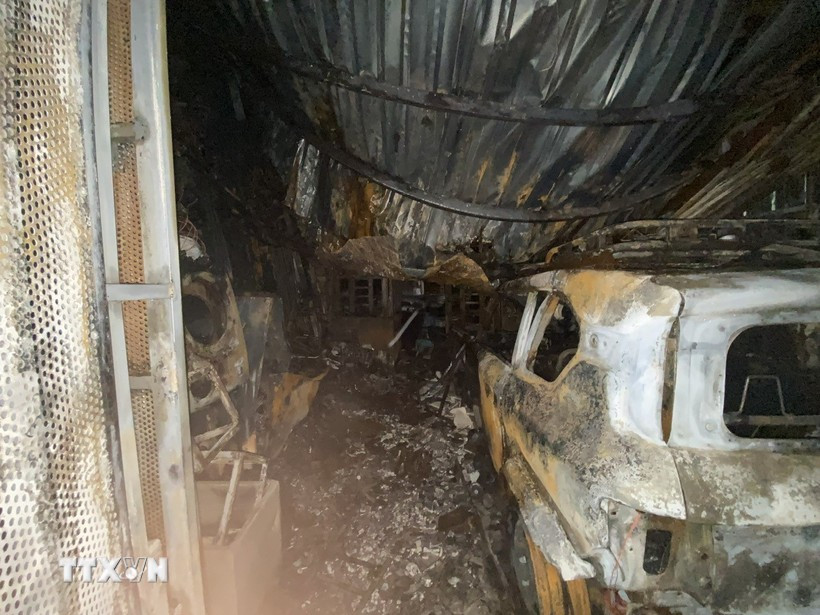 A car is burned down to its frame and left in the courtyard of the apartment complex. (Photo: VNA)