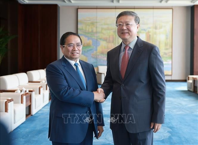 Prime Minister Pham Minh Chinh (left) meets with Chen Jining, Secretary of the Shanghai Municipal Committee of the Communist Party of China, on June 26, 2025. (Photo: VNA)