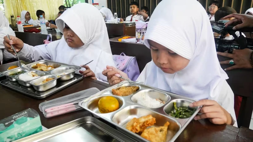 Students at an elementary school in Jakarta enjoy a free meal provided by the government for the first time. (Photo: asia.nikkei.com)