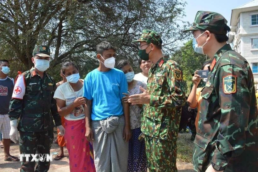 Personnel from the Vietnam People’s Army talk to Myanmar people about search and rescue efforts after the eathquake. (Photo published by VNA)