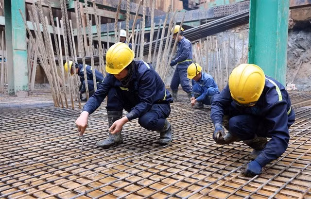Workers on the construction site of a bridge over the Red River in the border area between Lao Cai and China's Yunnan province. (Photo: VNS/VNA)