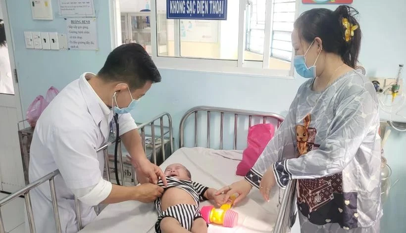 A doctor at Ho Chi Minh City Children's Hospital 1 examines a child with measles. (Photo: VNA)