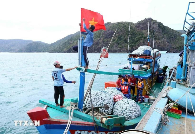 Fishermen prepare their vessels before setting sail, ensuring compliance with fishing regulations. (Photo: VNA)