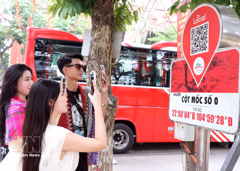 Visitors scan a QR code on the Km0 Ha Giang marker to access tourism information. (Photo: VNA)