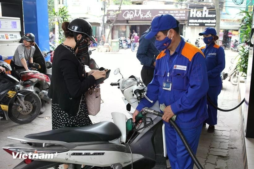 A woman has her motorcycle refilled at a gas station. (Photo: VNA)