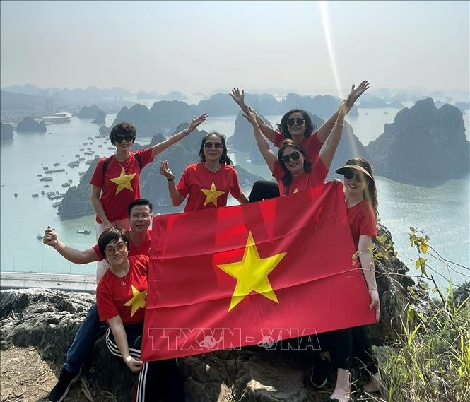 Tourists excited after conquering the peak of Bai Tho Mountain. (Photo: VNA)