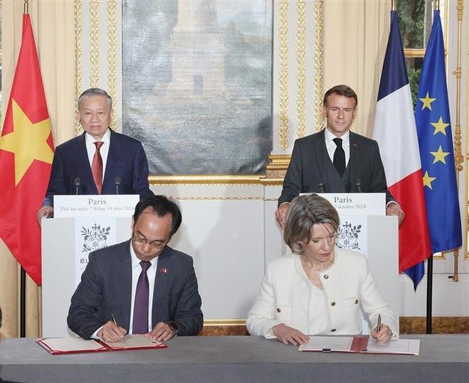 Lam and Macron witness the signing of an educational cooperation agreement between the two governments. (Photo: VNA) signing.jpg