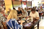 Foreign guests enjoy traditional Tet cuisine. (Photo: VNA)