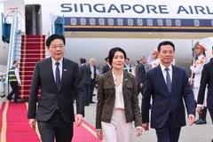 Prime Minister of Singapore Lawrence Wong (L) and his spouse (C) arrive in Hanoi on March 25 afternoon, beginning a two-day official visit to Vietnam. (Photo: VNA)