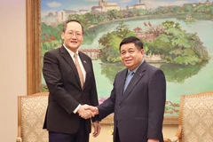 Deputy Prime Minister Nguyen Chi Dung (R) shakes hands with Singaporean Second Minister for Trade and Industry Tan See Leng. (Photo: VGP)