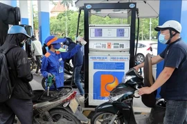Motorcyclists have their vehicles refilled at a Petrolimex gas station. (Photo: VNA)