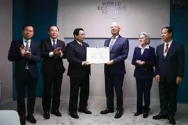 Prime Minister Pham Minh Chinh presents the honorary doctorate to Professor Klaus Schwab, Founder and Executive Chairman of the World Economic Forum. (Photo: VNA)