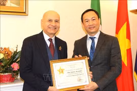 Vietnamese Ambassador to Italy Duong Hai Hung (right) hands over the "For the cause of Justice" insignia from the Vietnamese Ministry of Justice to former Italian Ambassador to Vietnam Antonio Alessandro. (Photo: VNA)