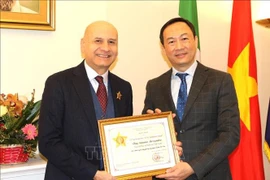 Vietnamese Ambassador to Italy Duong Hai Hung (right) hands over the "For the cause of Justice" insignia from the Vietnamese Ministry of Justice to former Italian Ambassador to Vietnam Antonio Alessandro. (Photo: VNA)