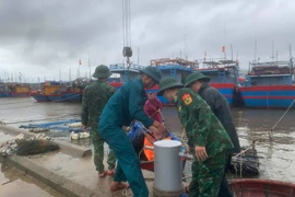 Border guard officers at Ky Ha Port Border Gate are assisting residents in securing their boats. (Photo: VNA)