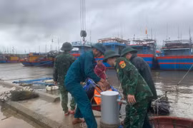 Border guard officers at Ky Ha Port Border Gate are assisting residents in securing their boats. (Photo: VNA)