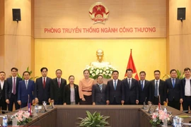 Minister of Industry and Trade Nguyen Hong Dien (6th from right) and Lao Ambassador to Vietnam Khamphao Ernthavanh (7th from right) have a working session in Hanoi on January 3. (Photo: tapchicongthuong.vn)