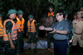 Prime Minister Pham Minh Chinh visits the forces working to reinforce the Cau River embankment, emphasising the need to ensure the dike’s safety. (Photo: VNA)