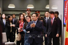 Prime Minister Pham Minh Chinh meets with staff of Vietnamese representative offices and the Vietnamese community in Kuwait on the evening of November 16. (Photo: VNA)