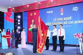 Party General Secretary To Lam pins the Ho Chi Minh Order onto the Vietnam News Agency’s flag at the ceremony on September 14. (Photo: VNA)