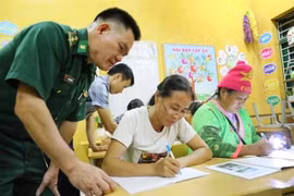 Lieutenant Lo Thanh Chuyen of the Leng Su Sin Border Guard Station assists teachers in a class in Ca Na Pa village in Diện Bien province. (Photo: VNA)