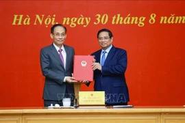 Prime Minister Pham Minh Chinh hands over the decision to assign Le Hoai Trung, Secretary of the Party Central Committee and Chief of the Party Central Committee Office, as Acting Minister of Foreign Affairs in Hanoi on August 30. (Photo: VNA)