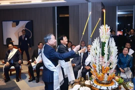 Party General Secretary To Lam (right) and Lao Party General Secretary and President Thongloun Sisoulith take part in Laos’ traditional wrist-tying ceremony on February 5. (Photo: VNA)