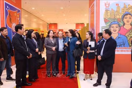 Deputy General Director of the Vietnam News Agency (VNA) Nguyen Thi Su introduces the VNA photo exhibition area at the 11th National Patriotic Emulation Congress to Vice State President Vo Thi Anh Xuan. (Photo: VNA)