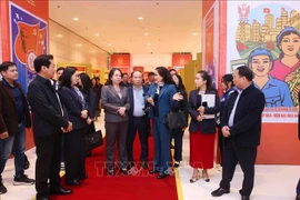 Deputy General Director of the Vietnam News Agency (VNA) Nguyen Thi Su introduces the VNA photo exhibition area at the 11th National Patriotic Emulation Congress to Vice State President Vo Thi Anh Xuan. (Photo: VNA)