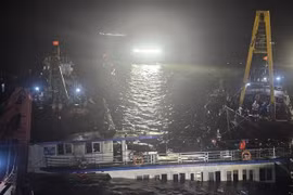 At 2:00 a.m. on July 20, rescue teams begin pumping water out of the capsized tourist boat before towing it ashore. (Photo: VNA)