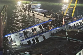 The capsized Vinh Xanh 58 tourist boat is salvaged and towed ashore early July 20 for further investigation. (Photo: VNA)