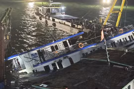 The capsized Vinh Xanh 58 tourist boat is salvaged and towed ashore early July 20 for further investigation. (Photo: VNA)