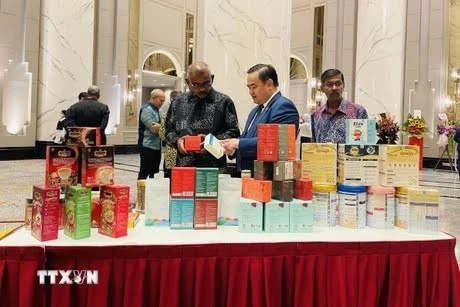 Vietnamese Trade Counsellor in Malaysia Le Phu Cuong introduces Vietnamese goods to customers (Photo: VNA)
