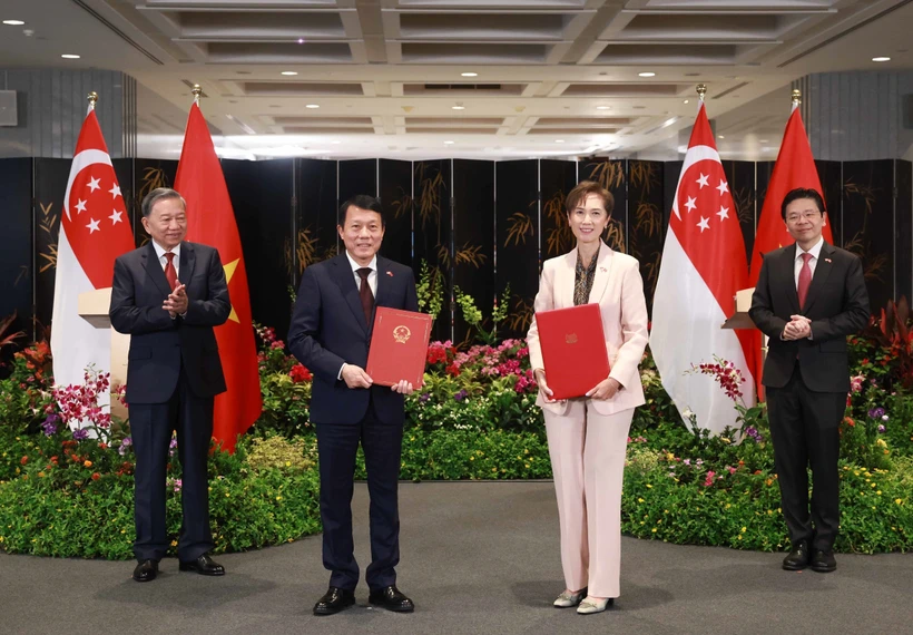 Party General Secretary To Lam (L) and Singaporean PM Lawrence Wong (R) witness the exchange of a MoU on digital transformation between the Vietnamese Ministry of Public Security and the Singaporean Ministry of Digital Development and Information on March 12. (Photo: VNA)