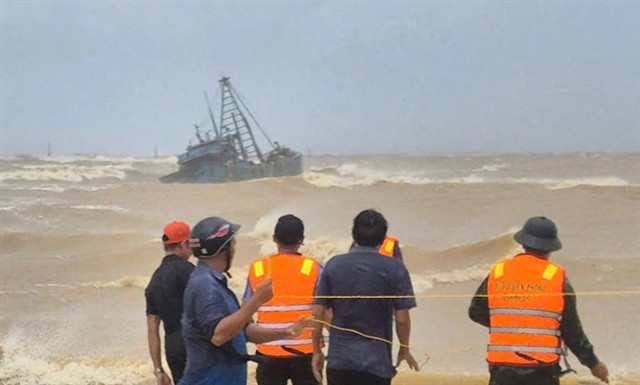 Rescue forces assist a fishing boat stranded at the breakwater of Cua Viet channel. (Photo courtesy of the Quang Tri Border Guard)