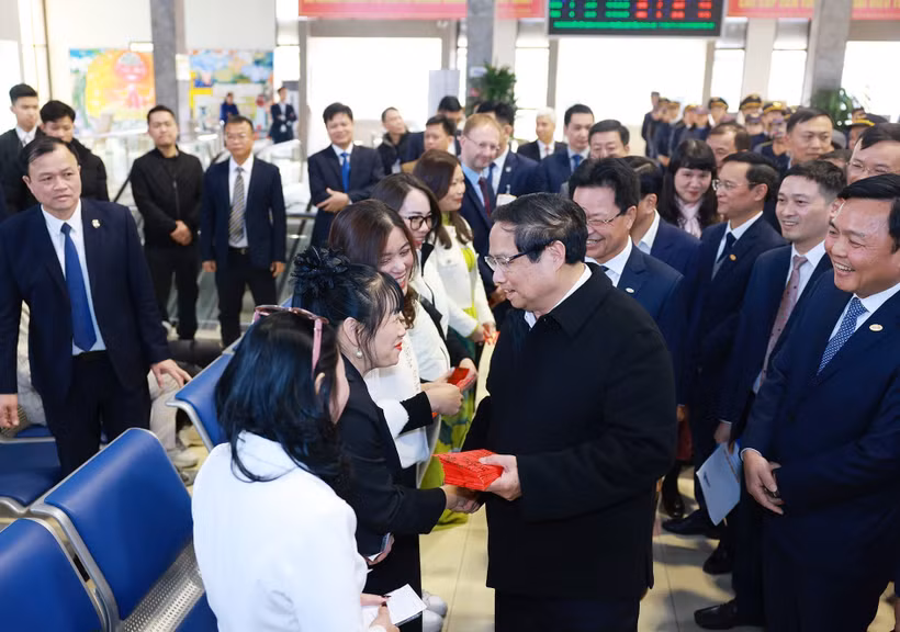 Prime Minister Pham Minh Chinh presents lucky money to passengers at the Hanoi Railway Station. (Photo: VNA) 